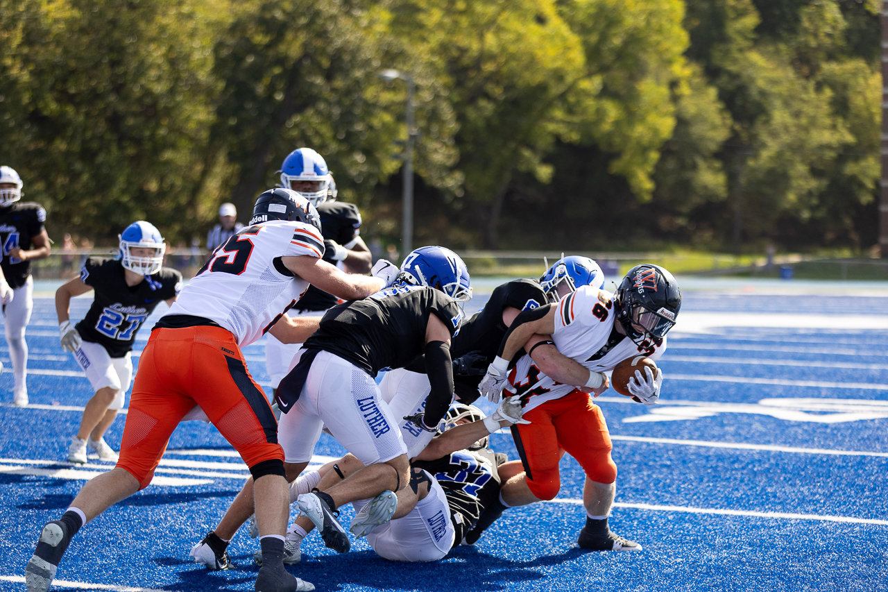 Third year running back Dawson Rud rushes as three opposing Luther players tackle him at Carlson Stadium on Oct. 4.  