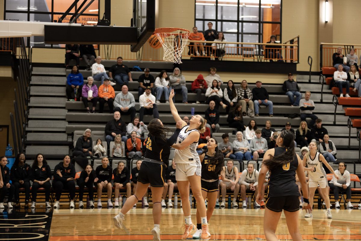 The Wartburg bench watches junior Lauren Golinghorst make a layup as Knox players defend their net. Photo by Karma Goodson.